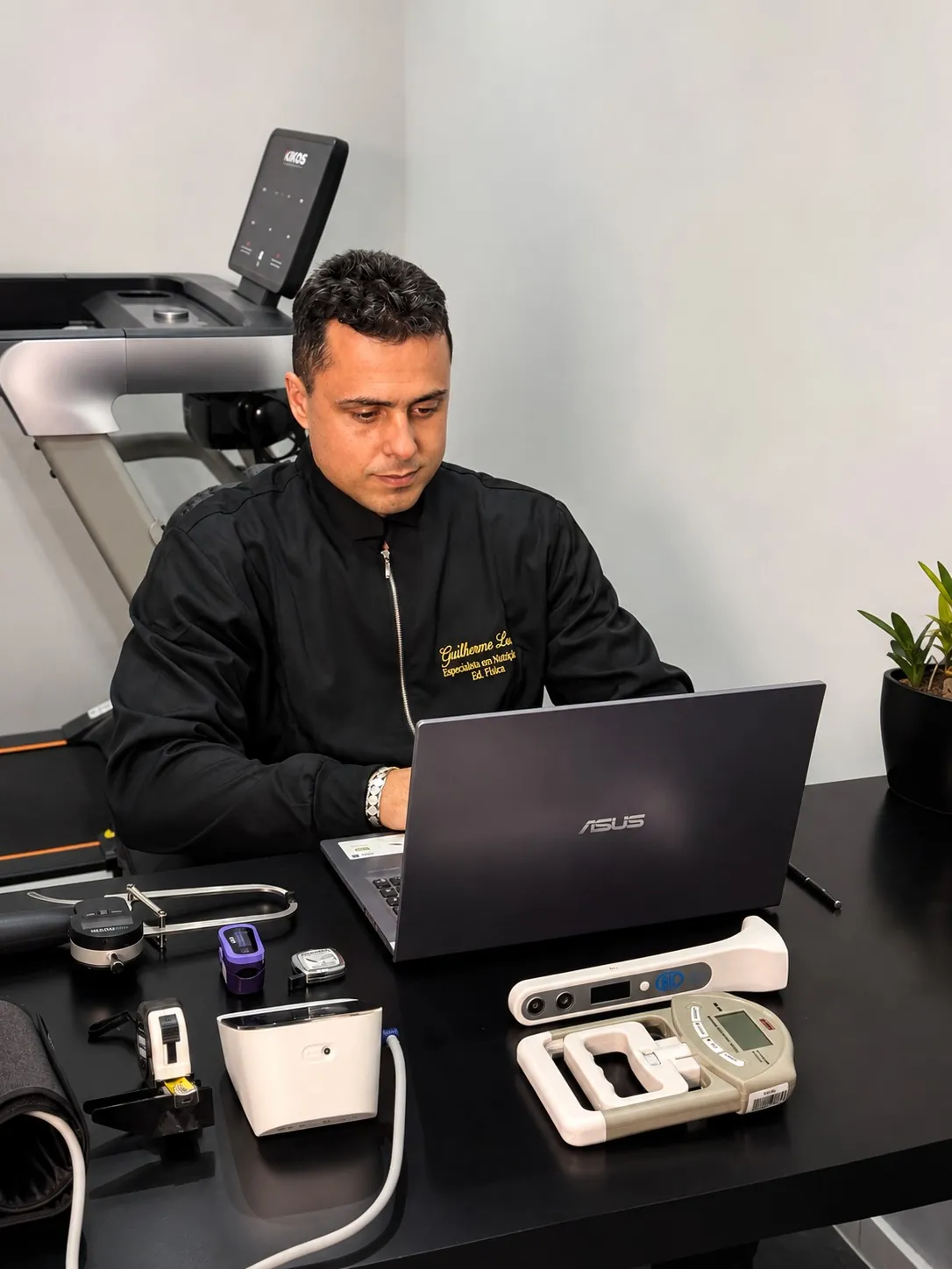 Guilherme Leal no consultório, com os aparelhos da avaliação física sobre a mesa