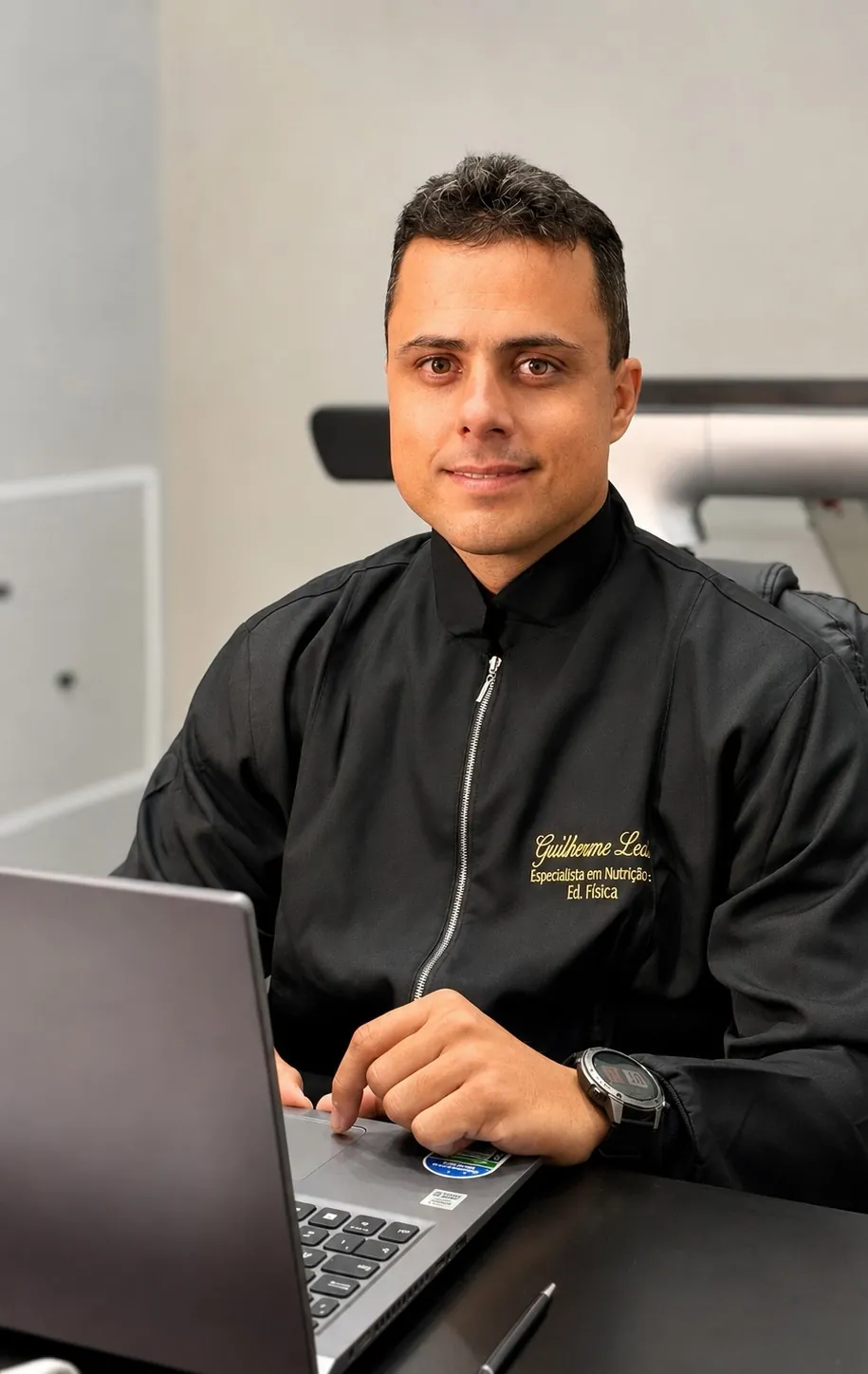Guilherme Leal sorrindo, sentado à mesa do consultório