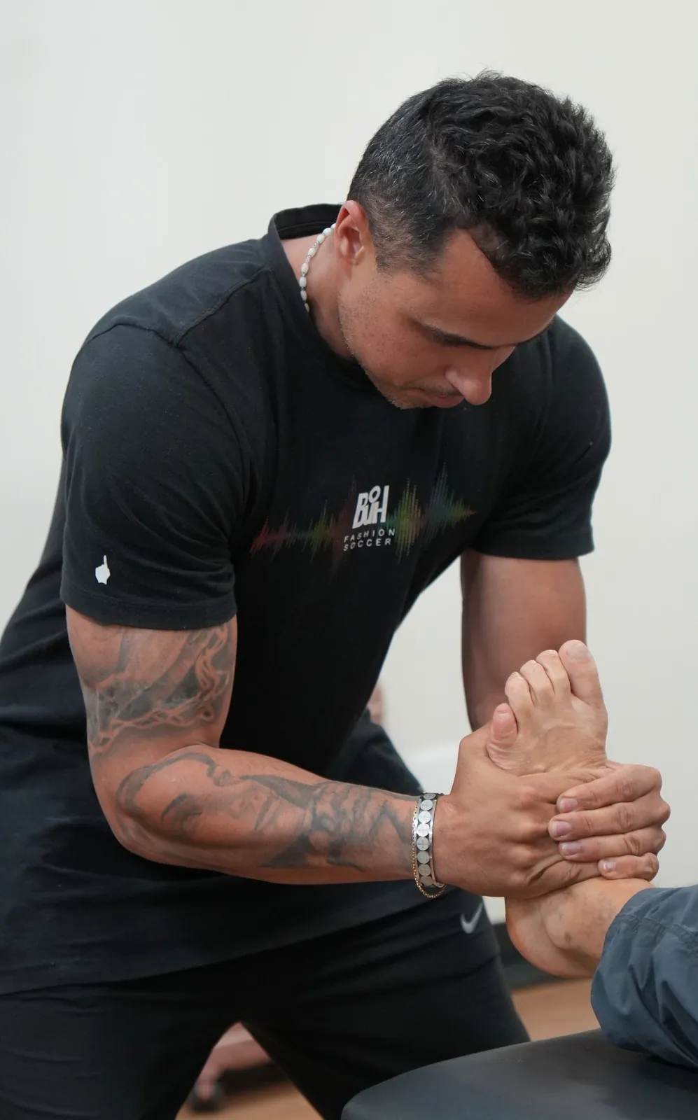 Guilherme Leal fazendo um ajuste de quiropraxia no pé de um paciente